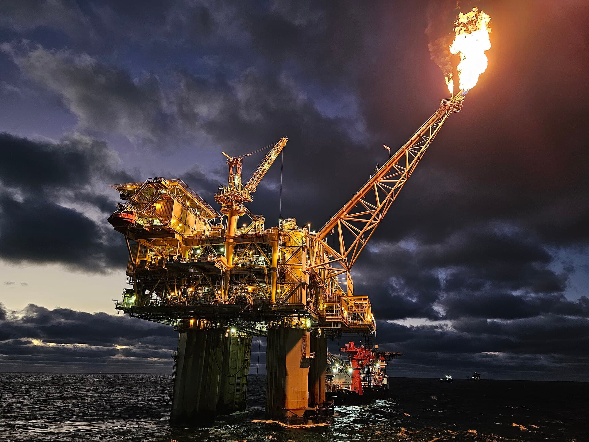 Offshore production platform at dusk with a gas flare